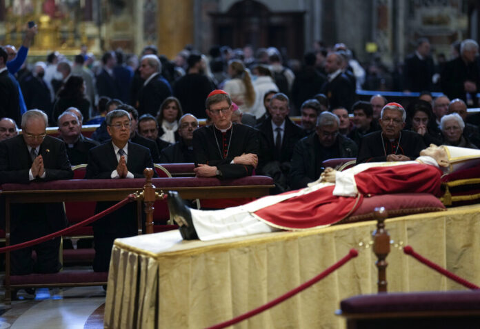FILE - Former Taiwan's Vice-President Chen Chien-jen, second from left, prays in front of the body of late Pope Emeritus Benedict XVI, his head resting on a pair of crimson pillows, lying in state in St. Peter's Basilica at The Vatican, Wednesday, Jan. 4, 2023. Photo: Antonio Calanni / AP File