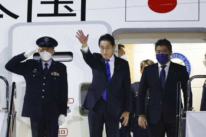 Japanese Prime Minister Fumio Kishida, center, prepares to leave Haneda airport in Tokyo Sunday, Jan. 8, 2023. Photo: Kota Endo / Kyodo News via AP