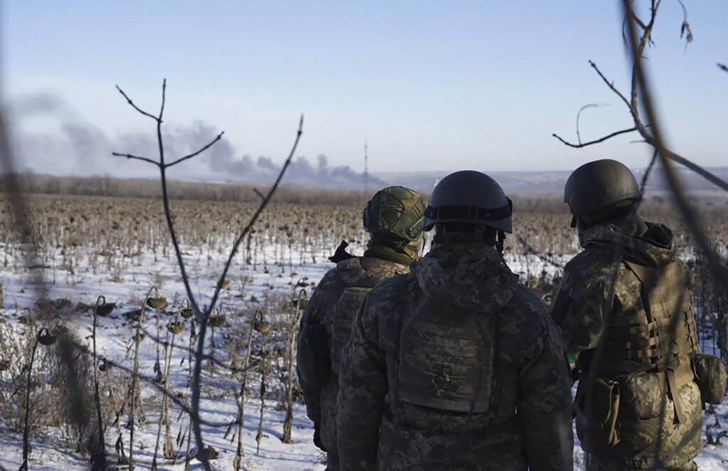 Ukrainian soldiers watch as smoke billows during fighting between Ukrainian and Russian forces in Soledar, Donetsk region, Ukraine, Wednesday, Jan. 11, 2023. Photo: Libkos / AP