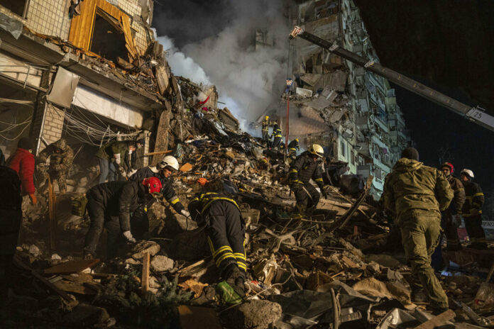 Emergency workers clear the rubble after a Russian rocket hit a multistory building leaving many people under debris in the southeastern city of Dnipro, Ukraine, Saturday, Jan. 14, 2023. Photo: Evgeniy Maloletka / AP