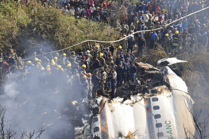 Nepalese rescue workers and civilians gather around the wreckage of a passenger plane that crashed in Pokhara, Nepal, Sunday, Jan. 15, 2023. Photo: Krishna Mani Baral / AP
