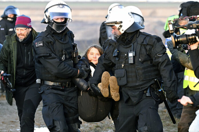Police officers carry Swedish climate activist Greta Thunberg away from the edge of the Garzweiler II opencast lignite mine during a protest action by climate activists after the clearance of Luetzerath, Germany, Tuesday, Jan. 17, 2023. Photo: Federico Gambarini / dpa via AP