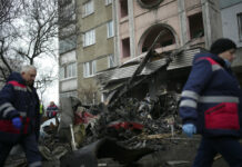 Ukraine Helicopter Crash Kills Interior Minister, Others Workers pass the scene where a helicopter crashed on civil infrastructure in Brovary, on the outskirts of Kyiv, Ukraine, Wednesday, Jan. 18, 2023. Photo: Daniel Cole / AP