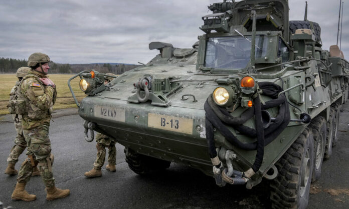 FILE - Soldiers of the 2nd Cavalry Regiment stand next to a Stryker combat vehicle in Vilseck, Germany, Wednesday, Feb. 9, 2022. Photo: Michael Probst / AP File