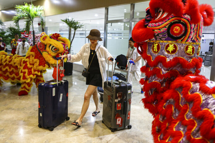 Dragon and Lion performers welcome a Chinese tourist arriving at the Ninoy Aquino International Airport in Manila on Tuesday, Jan. 24, 2023. Photo: Gerard V. Carreon / AP