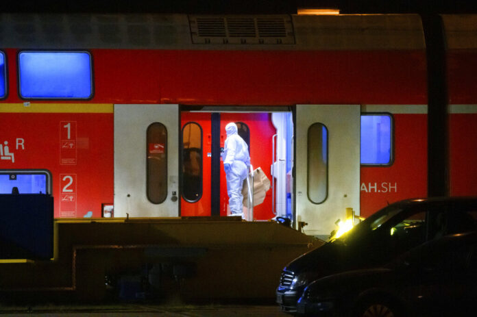 An investigator in a white protective suit works in the regional train that had been driven onto a siding in Neumunster, Germany, Wednesday, Jan. 25, 2023. Photo: Jonas Walzberg/dpa via AP