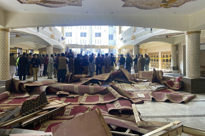 Security officials and rescue workers gather at the site of suicide bombing inside a mosque, in Peshawar, Pakistan, Monday, Jan. 30, 2023. Photo: Zubair Khan / AP