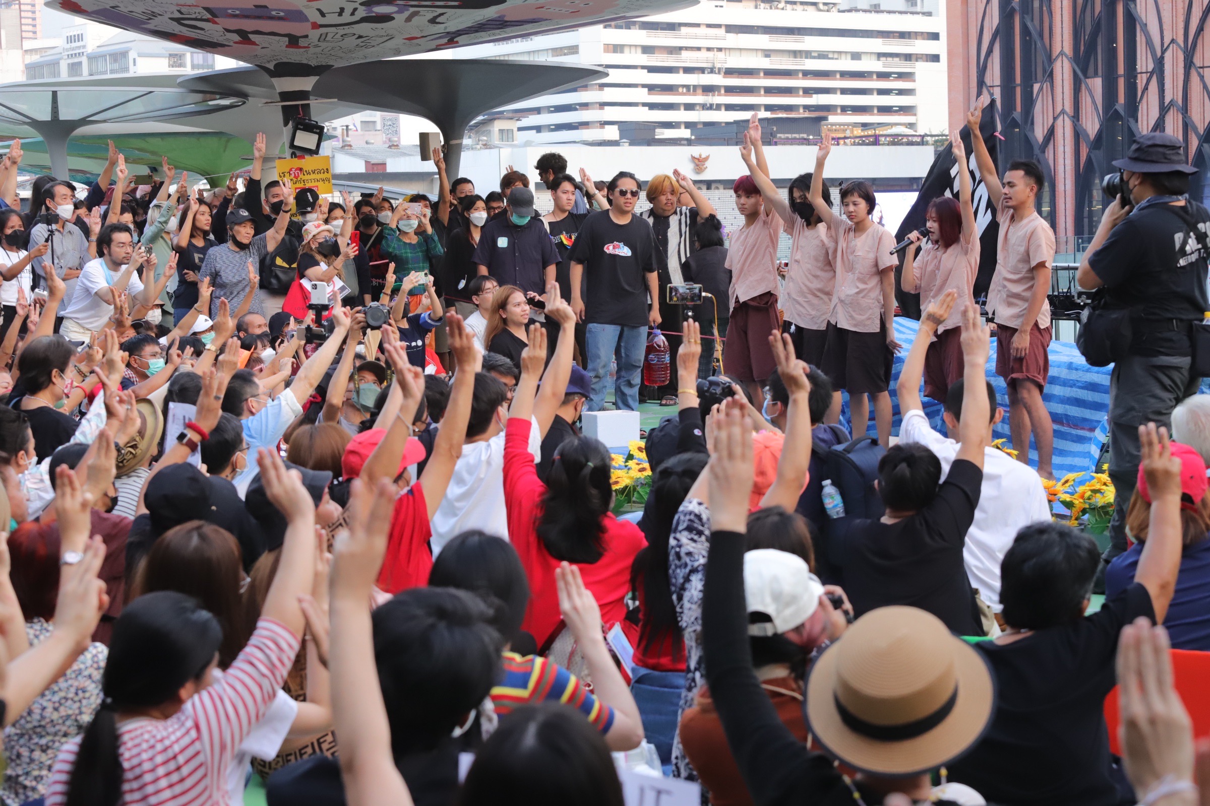 Protesters raises a three-finger salute during a rally supporting lese majeste detainees Tawan and Bam, who are on hunger strike, at Pathum Wan Intersection on Jan. 26, 2023.