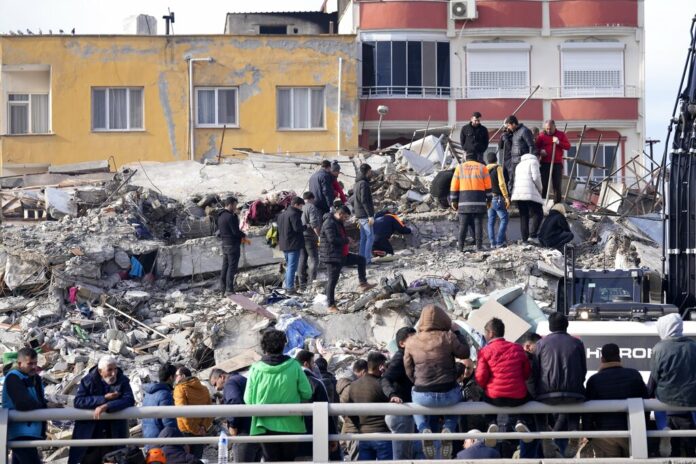 People and emergency teams search for survivors in the rubble of a destroyed building, in Iskenderun town, southern Turkey, Tuesday, Feb. 7, 2023. Photo: Hussein Malla / AP