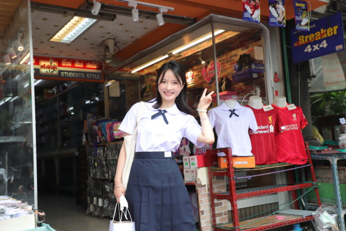 A Chinese tourist poses with her newly bought Thai student uniform in Bangkok on Mar. 7, 2023.