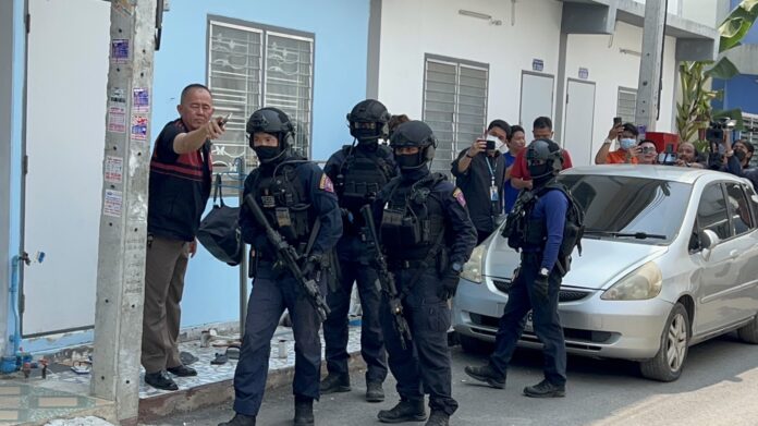 Police commandos take position outside a house in Bangkok’s Sai Mai district where a gunman is hiding on Mar. 14, 2023.