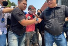 Man Arrested For Setting Fire and Stabbing Girlfriend to Death Pisutsiri Chansodam, center, being escorted by police to Bang Pu Police Station in Samut Prakan province on Mar. 7, 2023.