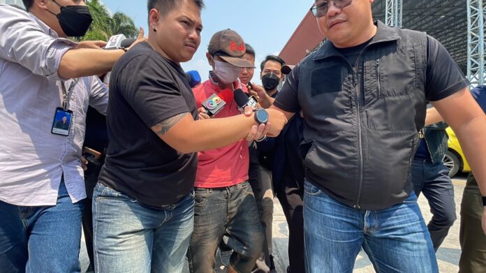 Pisutsiri Chansodam, center, being escorted by police to Bang Pu Police Station in Samut Prakan province on Mar. 7, 2023.