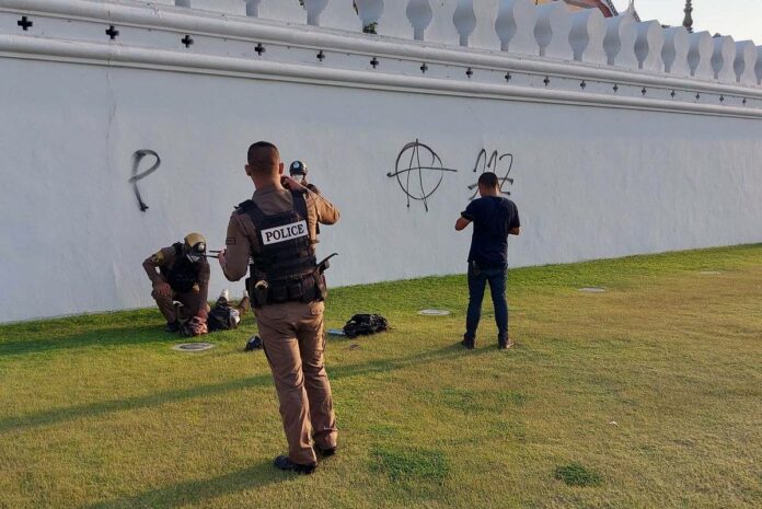 Police arrest a man who graffiti the wall of the Grand Palace complex on Mar. 28, 2023.