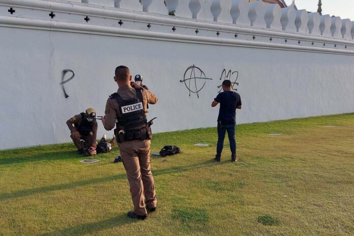 Police arrest a man who graffiti the wall of the Grand Palace complex on Mar. 28, 2023. Police arrest a man who graffiti the wall of the Grand Palace complex on Mar. 28, 2023.
