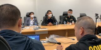 Hacker “9Near” Surrenders to Police Sgt. Maj. Khemarat Boonchuay, center, accompanied by a military officer at the Cyber Crime Investigation Bureau on Apr. 12, 2023.