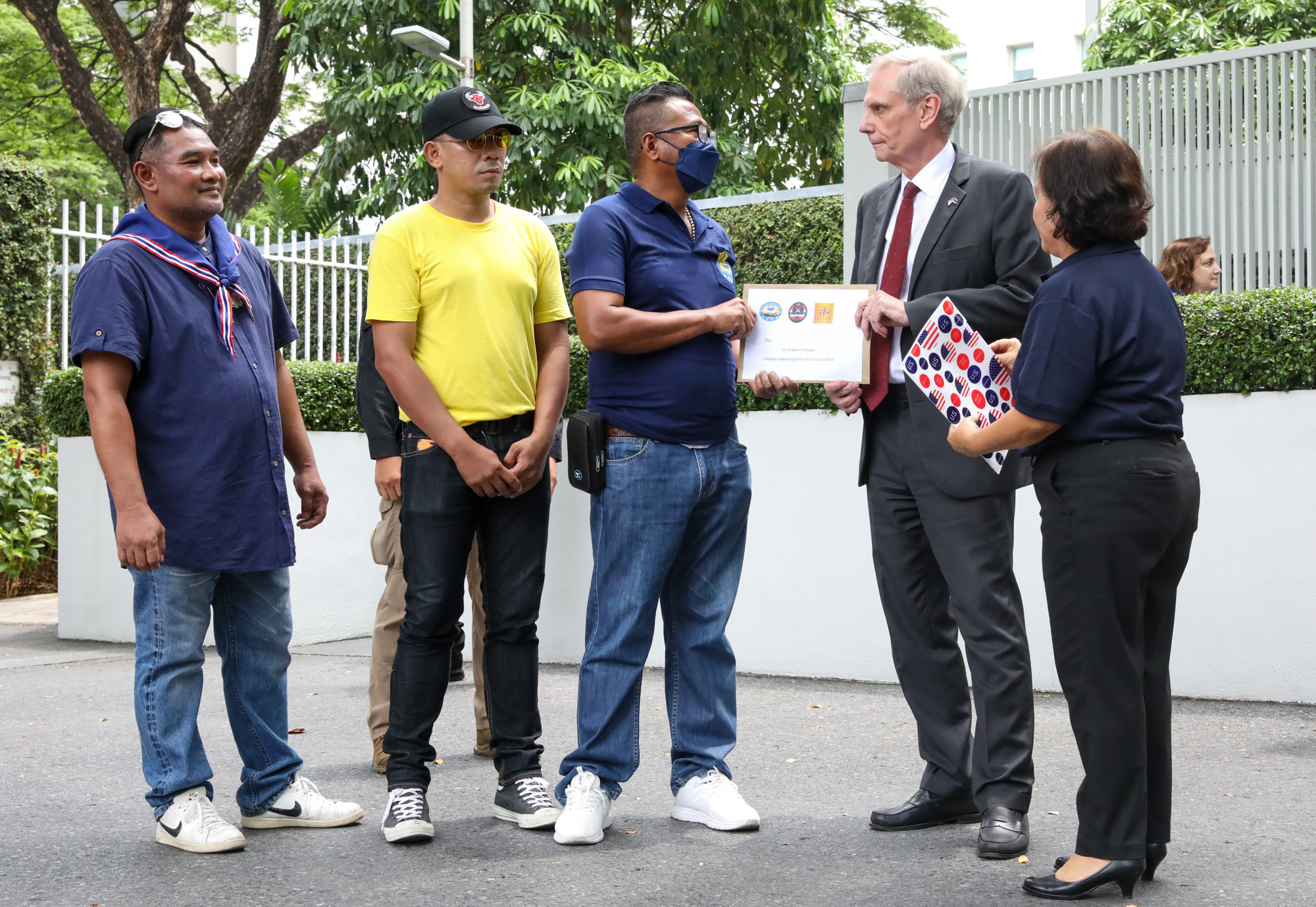 In this photo released by U.S. Embassy Bangkok, U.S. Ambassador Robert Godec receives a petition from a group of royalist demanding the U.S to stop interfering with Thai domestic affairs on May 24, 2023. Photo: U.S. Embassy Bangkok / Facebook