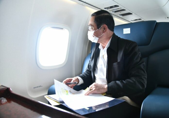 A file photo of PM Prayut Chan-o-cha looking through an airplane window.