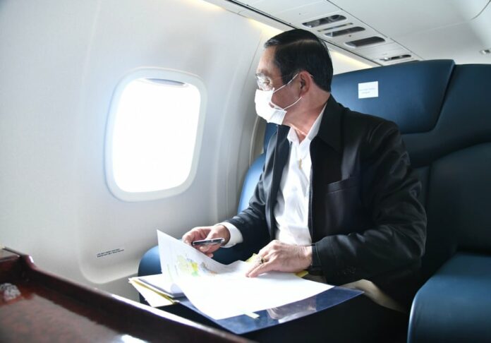 A file photo of PM Prayut Chan-o-cha looking through an airplane window. A file photo of PM Prayut Chan-o-cha looking through an airplane window.