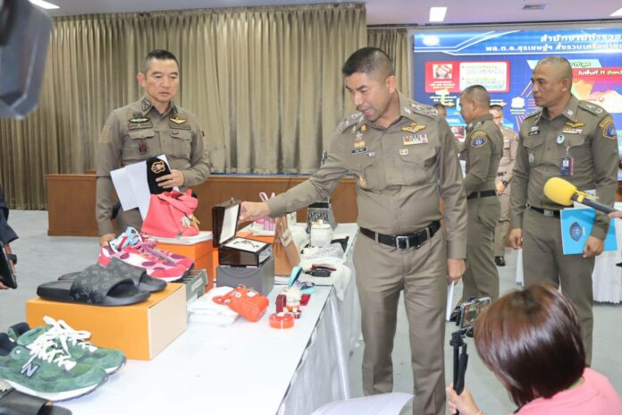 Deputy police commissioner Surachate Hakparn inspects a luxury watch seized from an online gambling network at the Crime Suppression Division on Jul. 21, 2023.