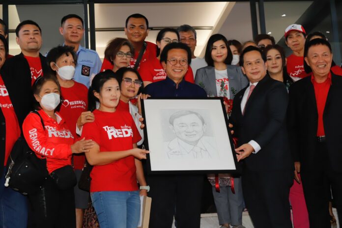 Pheu Thai Party supporters give a drawing of Thaksin Shinawatra to Pheu Thai MP Thossaporn Sereerak at the party’s headquarters on Jul. 26, 2023.