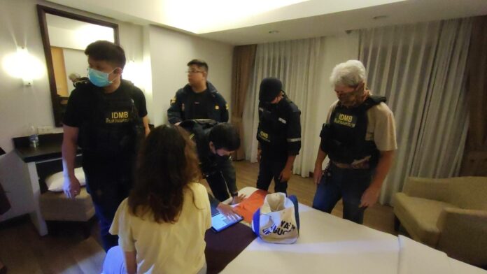 Police officers question the victim at a hotel in Bangkok on Aug. 11, 2023.
