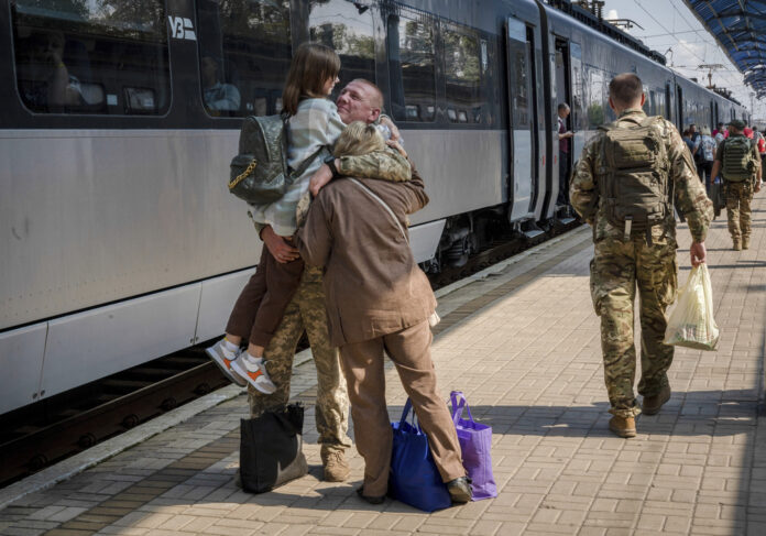 A Ukrainian serviceman hugs his wife and the daughter at the railway station in Sloviansk, Donetsk region, Ukraine on Tuesday, Sept. 12, 2023. Photo: Hanna Arhirova / AP