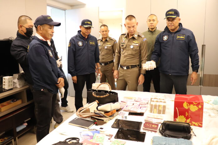 Police inspect cash and luxury items seized from a cryptocurrency scam network in a hotel in Rama IX area.