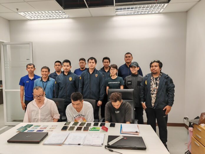 Police officers and a representative from Taiwanese police pose with the suspects at the immigration police headquarters in Bangkok on Nov. 8, 2023.