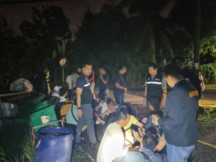 Police question a group of migrant workers arrested for illegally working in Phuket province on Dec. 19, 2023.