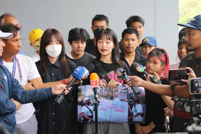 Monarchy reform activist Tawan Tuatulanond speaks to reporters after she files a complaint at Pathum Wan Police Station over the clash with a group of ultra-royalists at BTS Siam Station earlier the day on Feb. 10, 2024.