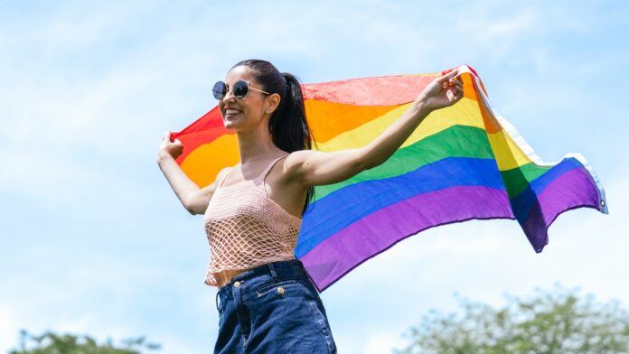 Joyful Woman Celebrating With LGBT Flag in Sunny Park