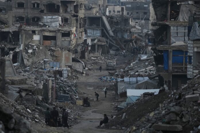 Streets covered in rubble in gaza An aerial shot of a street in gaza covered in rubble with a small path cleared in the middle and destroyed building all aroudn.
