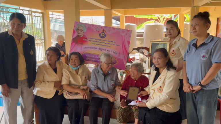 Mrs. Tu Kongkasem in a group photo being presented her centenarian award with several other health officials in frame