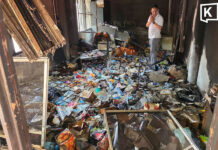 Temple fire reveals unexpected items in abbot’s kuti A room several meteres long and a few metres wide is strewn with trash. Windows let in daylight and there is an official in a whiteshirt standing in the garbage, which covers his ankles.