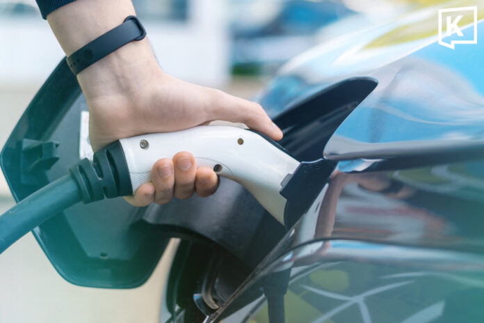 man-charging-ev a picture of a man holding an EV charger in an EV