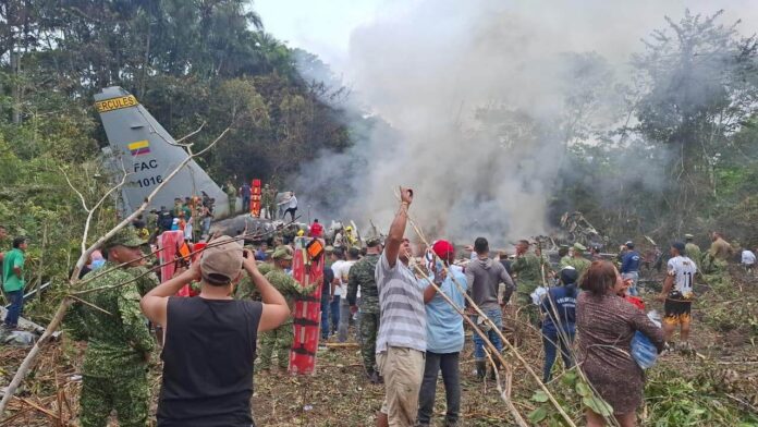 Colombia Plane Crash People stand around a military cargo plane that crashed after taking off from Puerto Leguizamo, Colombia, a remote municipality in the Amazonian province of Putumayo, Monday, March 23, 2026. (MiPutumayo via AP)