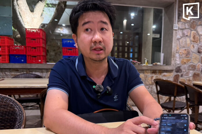 hotel-owner-crypto-scam The victim shows reporters the Google Authenticator app on his phone while explaining the suspected unauthorised crypto trades that drained millions of baht from his account
