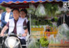Anutin drives motorcycle grocery cart around Thai Khu Fah Building to promote the Thai Help Thai campaign