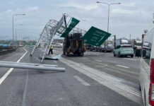 Crane truck hits road sign, blocking three traffic lanes Crane truck hits road sign, blocking three traffic lanes