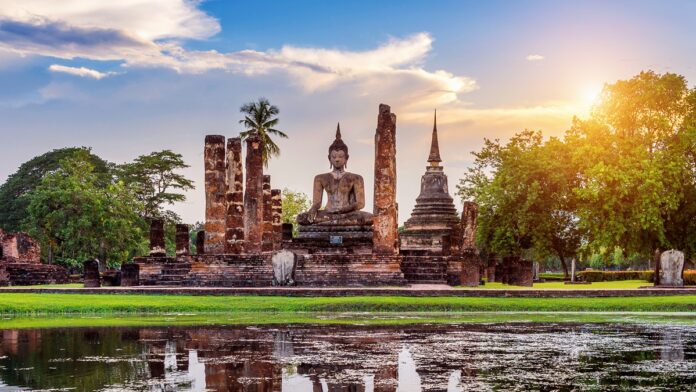 Buddha statue and Wat Mahathat Temple in the precinct of Sukhoth