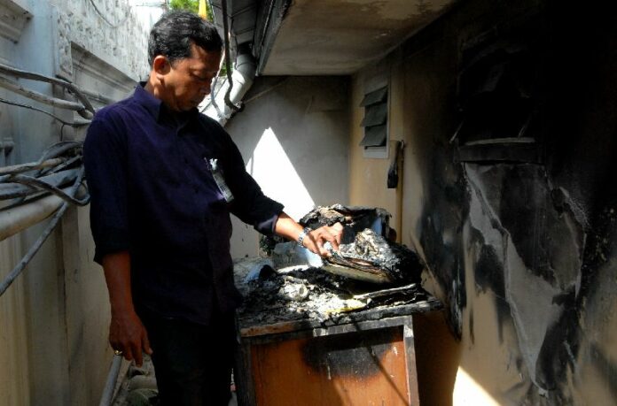 Official checking the scene of small fire at Government House
