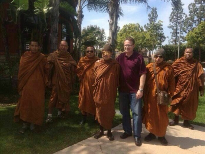 Mr. Wirapol Sukphol (center, next to the Caucasian individual) after he narrowly escapes from the DSI in Laos.