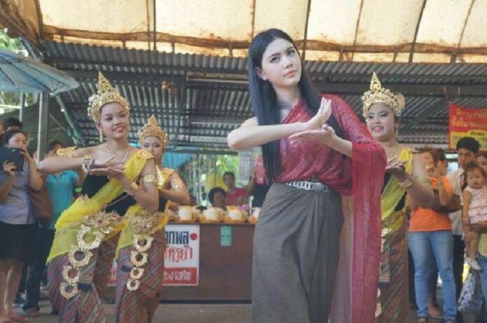 Famous actress Davika 'Mai' Horne performing traditional Thai dancing in front of shrine dedicated to the ghost of Mae Nak in Bangkok
