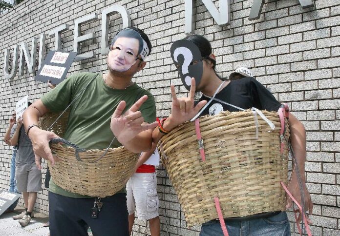 Protesters against the 'blanket amnesty' bill, which is also nicknamed as 'Mao Keng (all in the basket' amnesty, in front of the United Nations office in Bangkok, 24 October 2013.