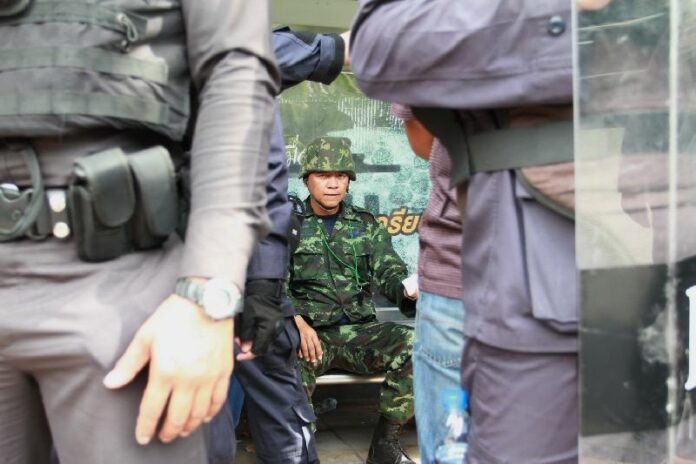 A group of police officers surrounded a retired military captain who attempted to approach the Government House with his fellow protesters to protest against PM Yingluck Shinawatra, 14 November 2013