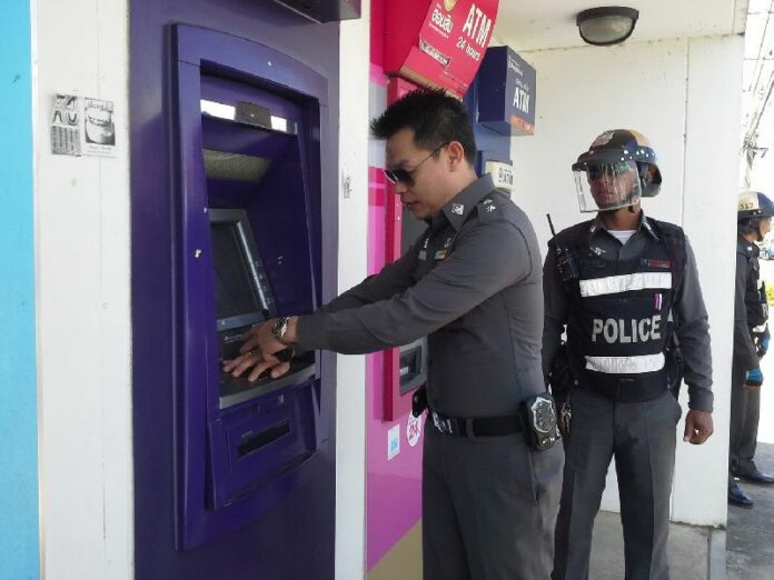 Police officers in Udon Thani province inspecting an ATM to look for skimming device, following cases of widespread skimming scheme, 19 November 2013