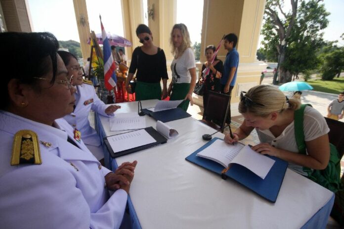 Westerners signing good wishes for His Majesty the King on the occasion of his birthday in Ayutthaya, 5 December 2013