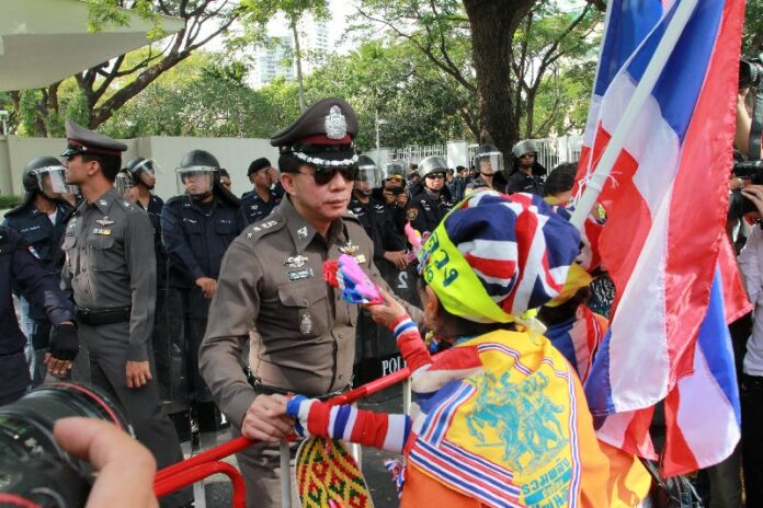 Anti-government protesters confronting police officers in front of the US Embassy in Bangkok, 19 December 2013
