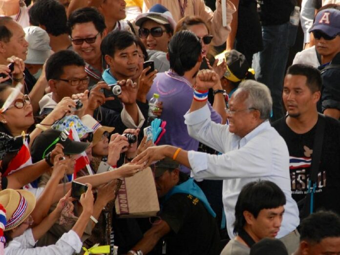 Anti-government protest leader Suthep Thaugsuban greeting supporters during a 'warm-up' march before the planned "shutdown" of Bangkok, 7 January 2014